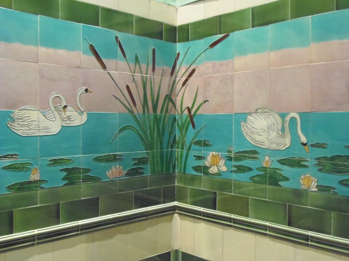 Les murs d'une petite pièce, derrière le hall d'entrée, sont décorées par des panneaux en céramique représentant des cygnes flottant entre nénuphars et roseaux.