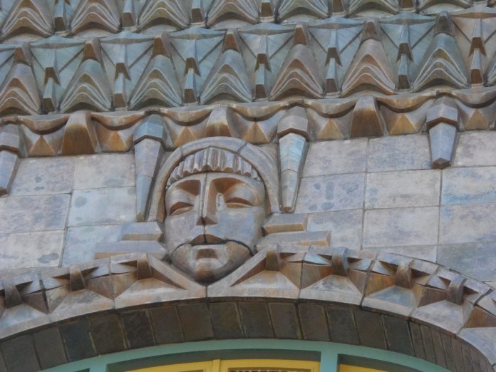 Visant sculpté dans la pierre surmontant une ouverture du cinéma Tuschinski à Amsterdam.